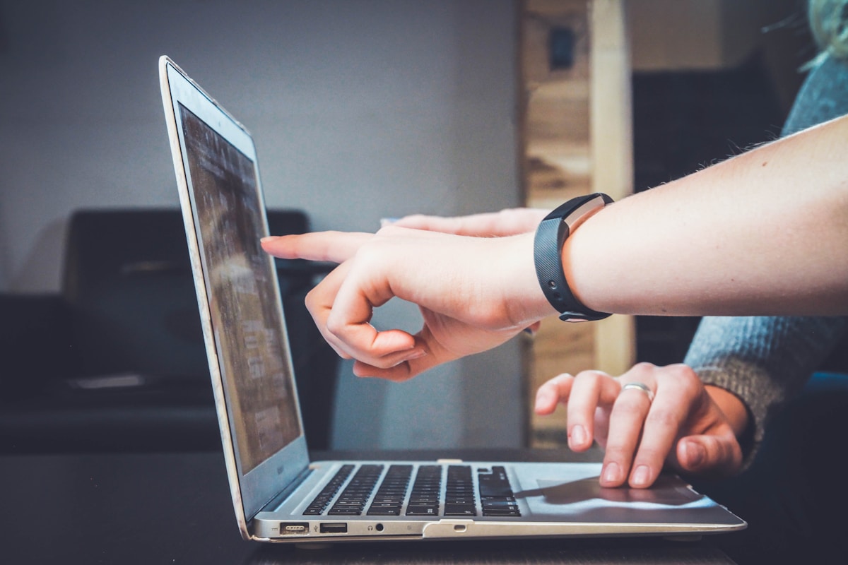 Professional reviewing AI-assisted client deliverables on a laptop